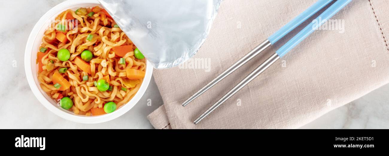 Coupe de ramen, nouilles soba instantanées dans une tasse en plastique avec des légumes et des baguettes panoramiques Banque D'Images
