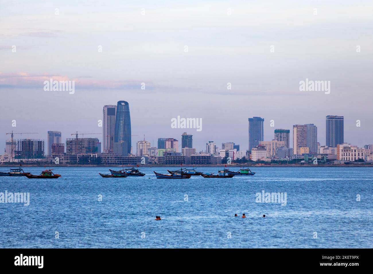 Personnes nageant à la plage Nguyen Trai à Da Nang au crépuscule. Banque D'Images