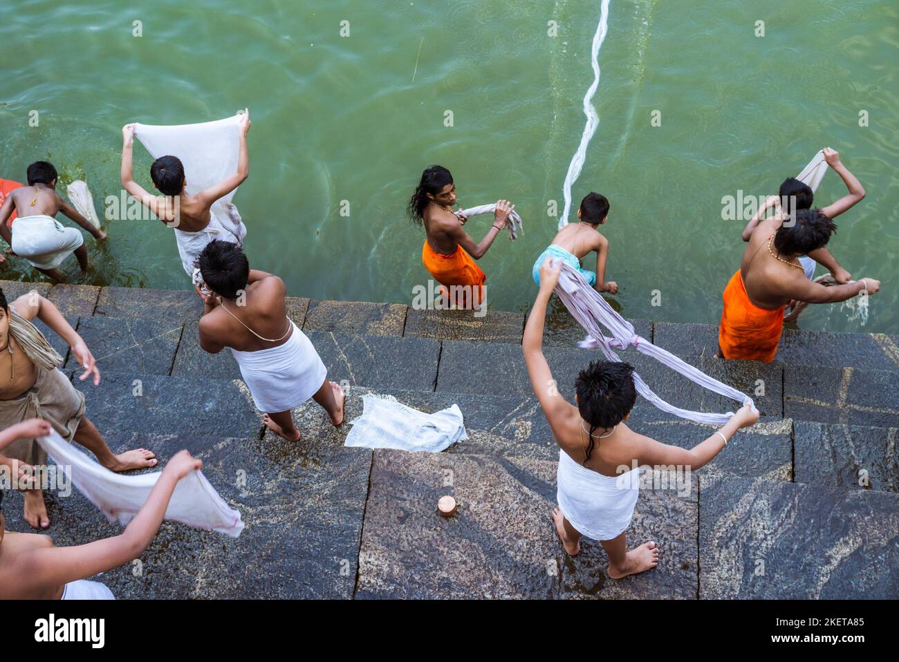 Udupi, Karnataka, Inde : les jeunes novices brahmin lavent leurs vêtements au réservoir d'eau Madhva Sarovara adjacent au temple Krishna du 13th siècle.Le Banque D'Images