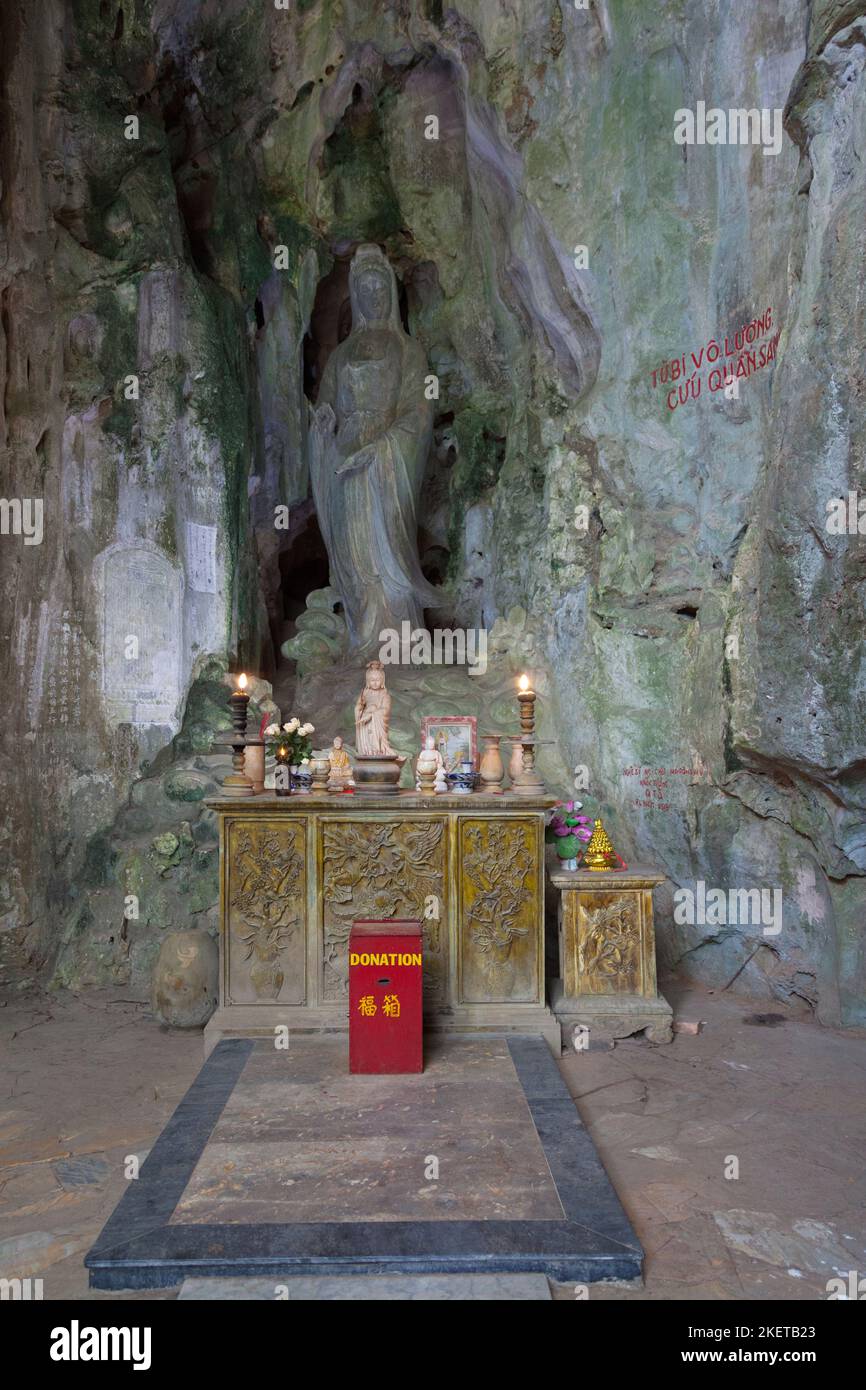 Petit sanctuaire devant une statue de Guanyin directement sculptée dans la pierre de marbre à l'entrée de la grotte de Huyen Khong à Da Nang. Banque D'Images