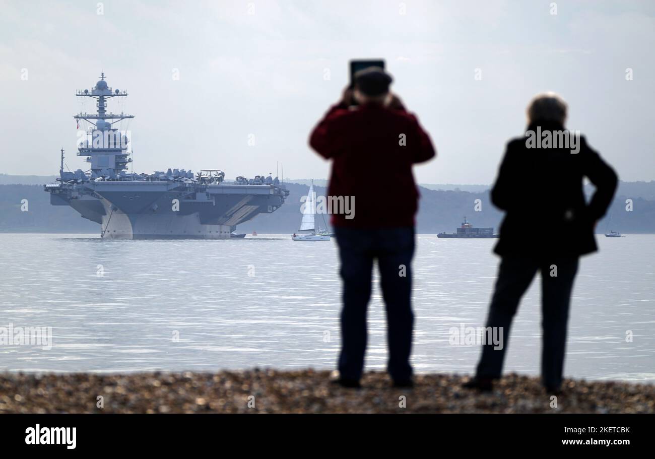 Les gens regardent l'USS Gerald R. Ford lorsqu'ils sont à l'ancre dans Stokes Bay, dans le Solent, alors que le « plus grand navire de guerre du monde » passera quatre jours à s'ancrer au large de la côte du Hampshire pendant son déploiement inaugural. Date de la photo: Lundi 14 novembre 2022. Banque D'Images