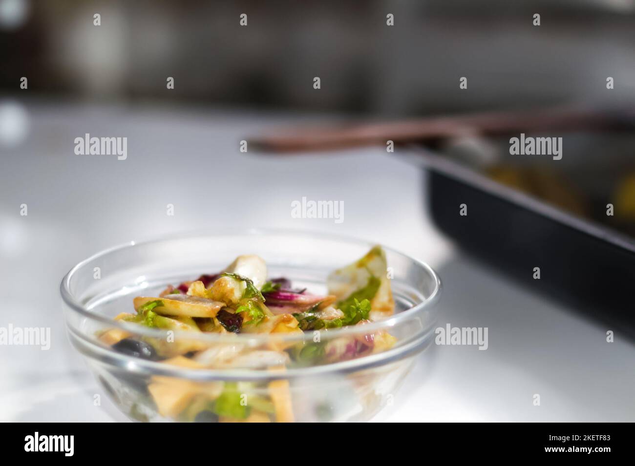 Défocus bol en verre avec salade sur fond blanc. Différentes feuilles de légumes à feuilles, verger, épinards, arugula en salade. Salade au fromage Banque D'Images