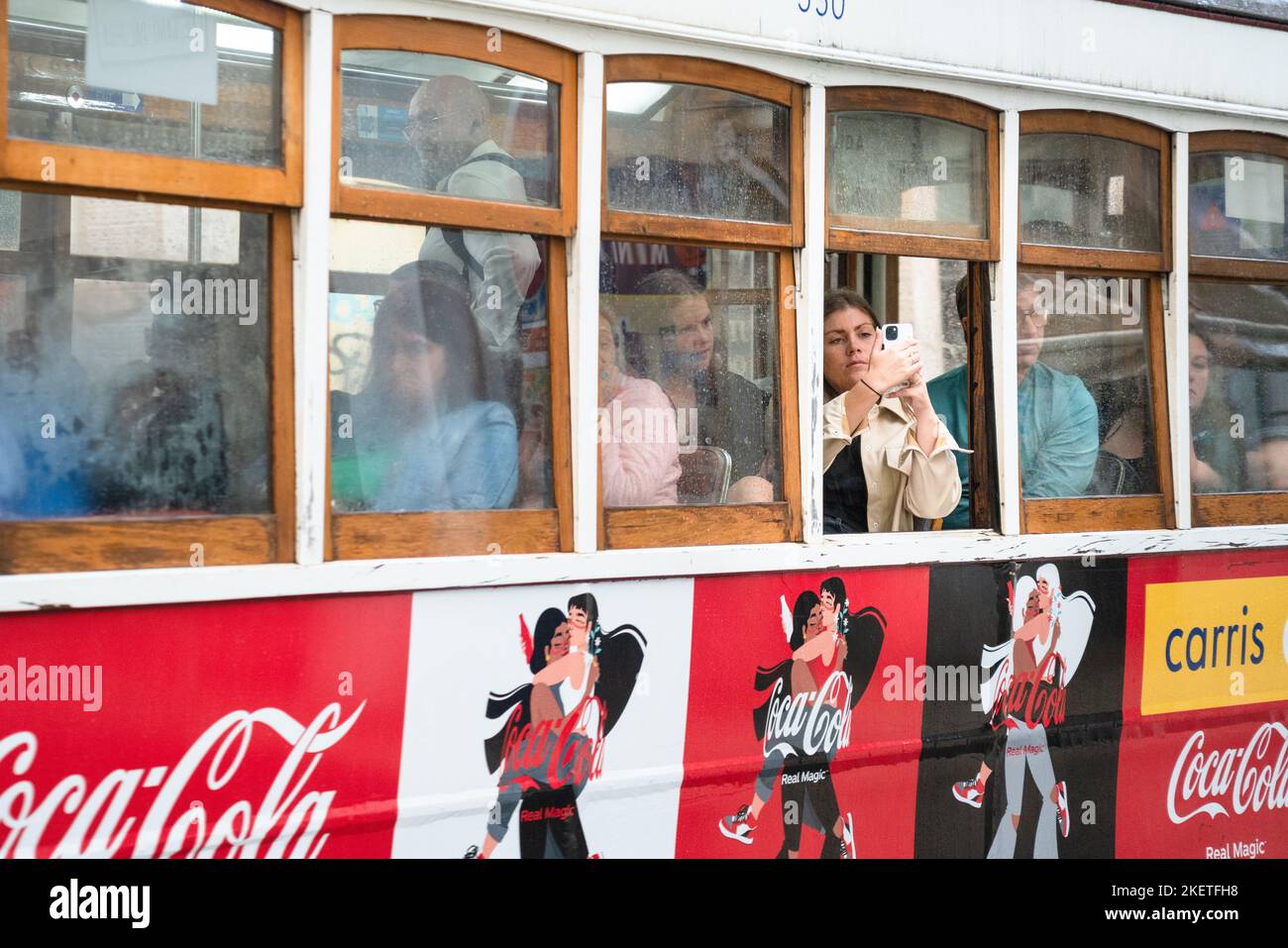 Les fenêtres du tramway de Lisbonne brumisent dans la tempête et un touriste prend des photos. Les gens ont besoin de se mettre à l'abri pendant une tempête typiquement abondante d'automne Banque D'Images