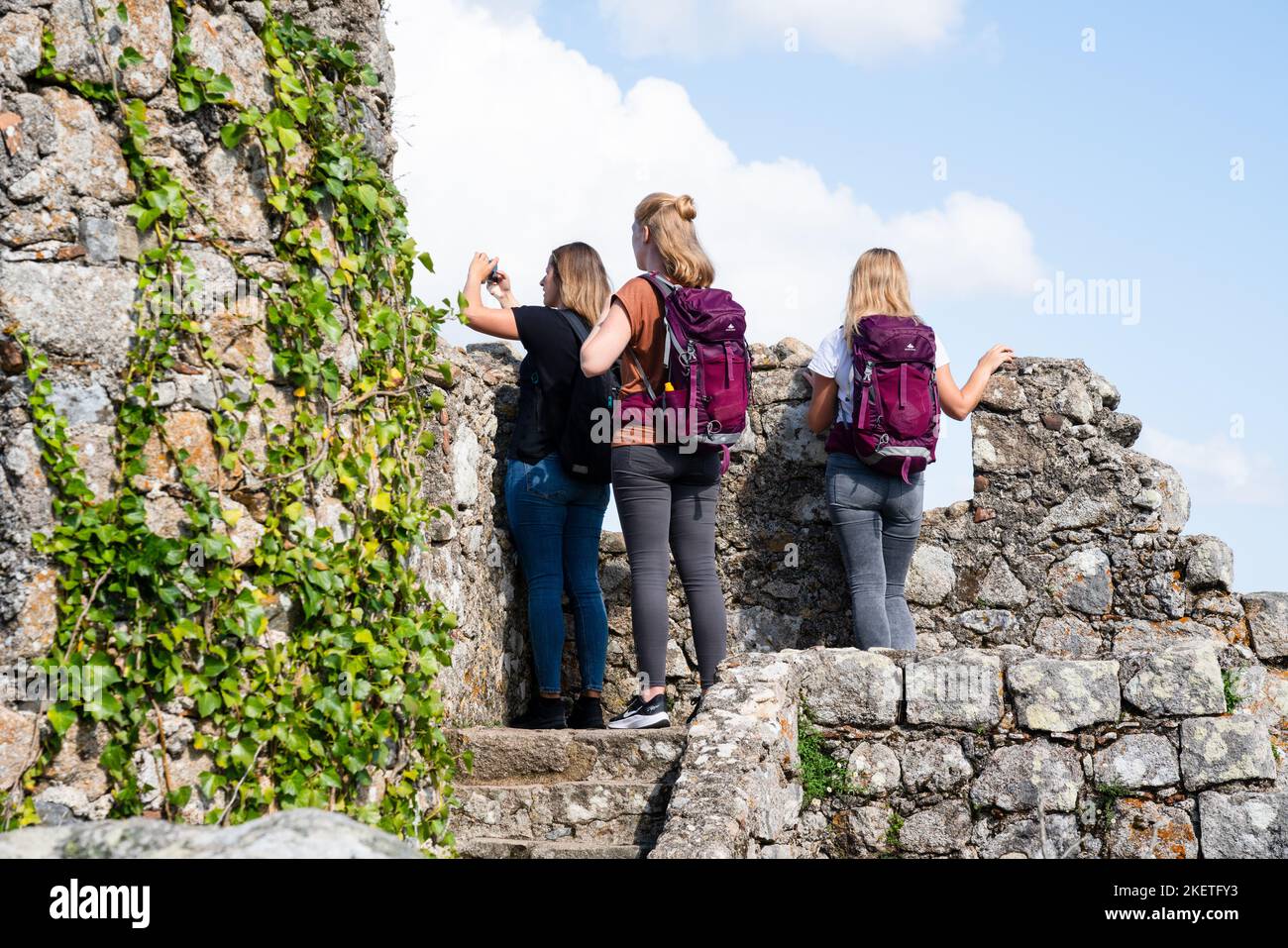 Les touristes grimpent les murs fortifiés et les tourelles du château mauresque des Maures datant du 10th siècle (Castelo dos Mouros) au-dessus de Sintra, Portugal. Banque D'Images