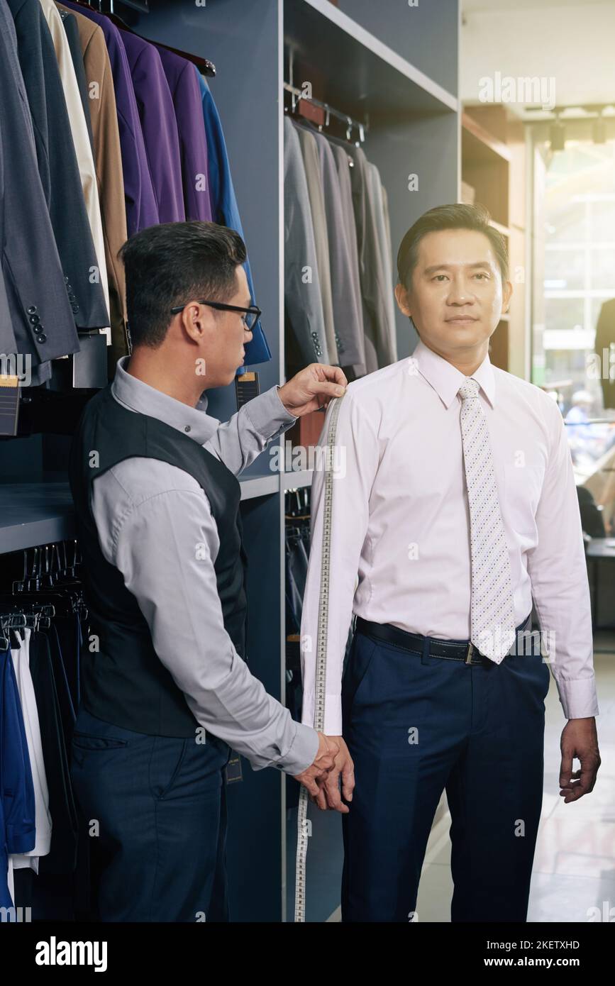 Un homme vietnamien mature à l'atelier commandant un costume Banque D'Images