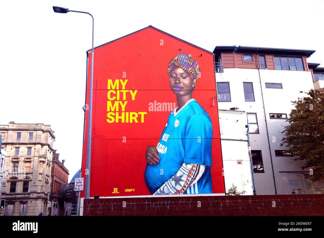 'My City My shirt' murale femme galloise africaine portant un maillot de football Jersey Butetown Cardiff Bay pays de Galles Royaume-Uni Grande-Bretagne KATHY DEWITT Banque D'Images