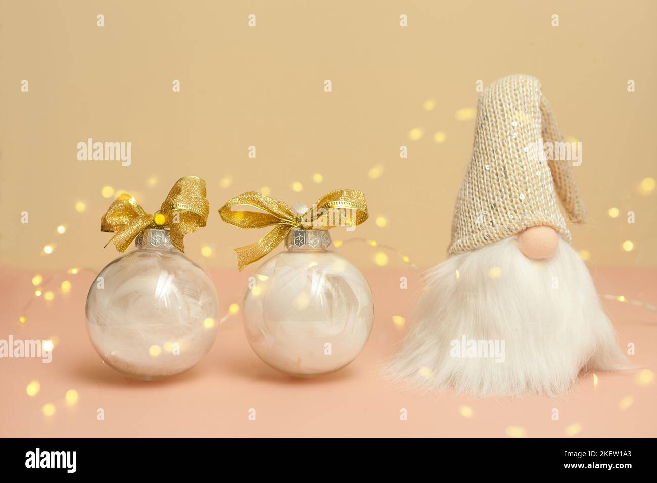 gnome et boules de noël avec bokeh sur rose - blanc décorations avec plumes. Cadeaux du nouvel an Banque D'Images