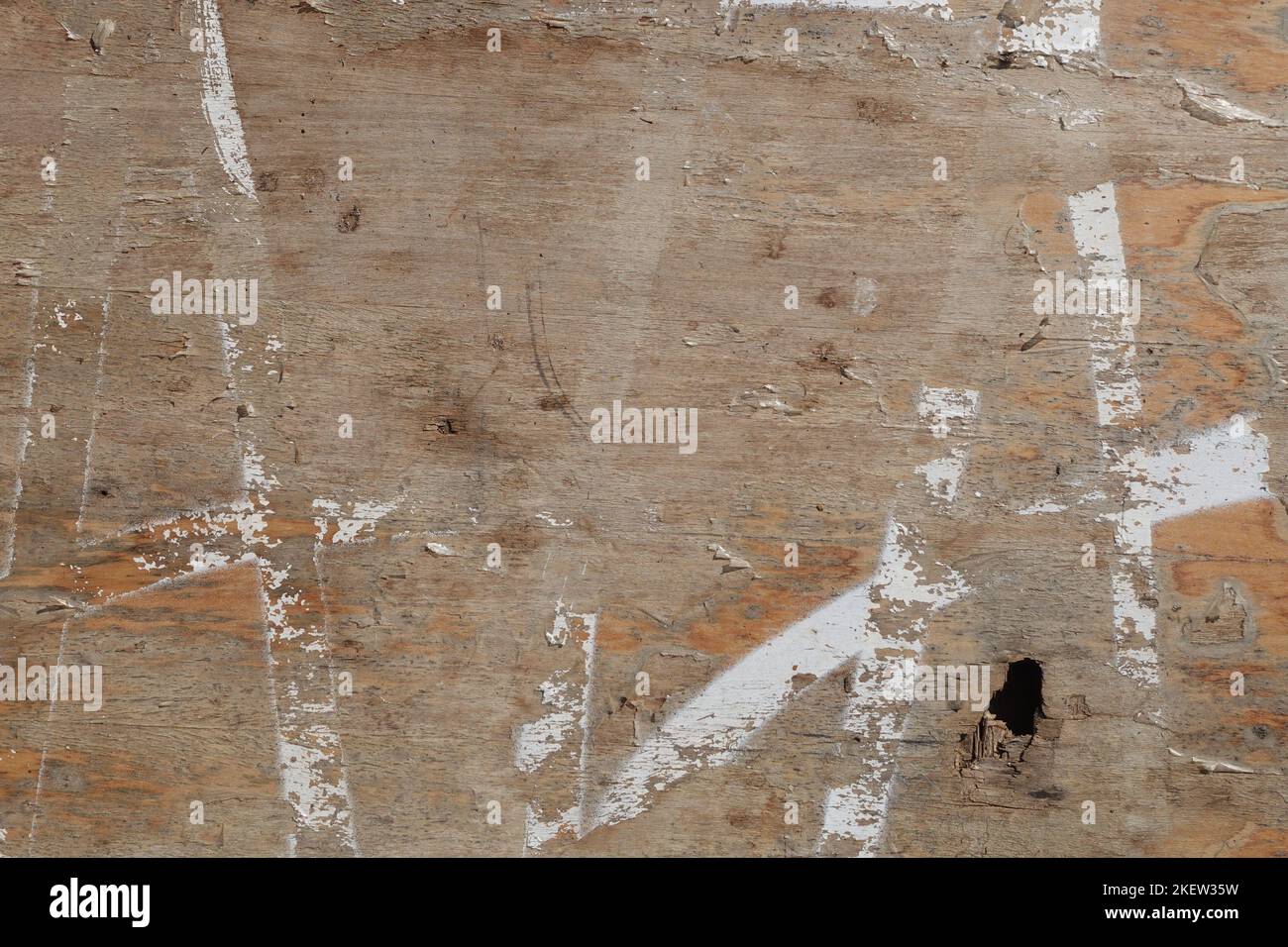 Arrière-plan en bois abîmé avec des lignes de peinture blanches ébréchées et un trou. Banque D'Images
