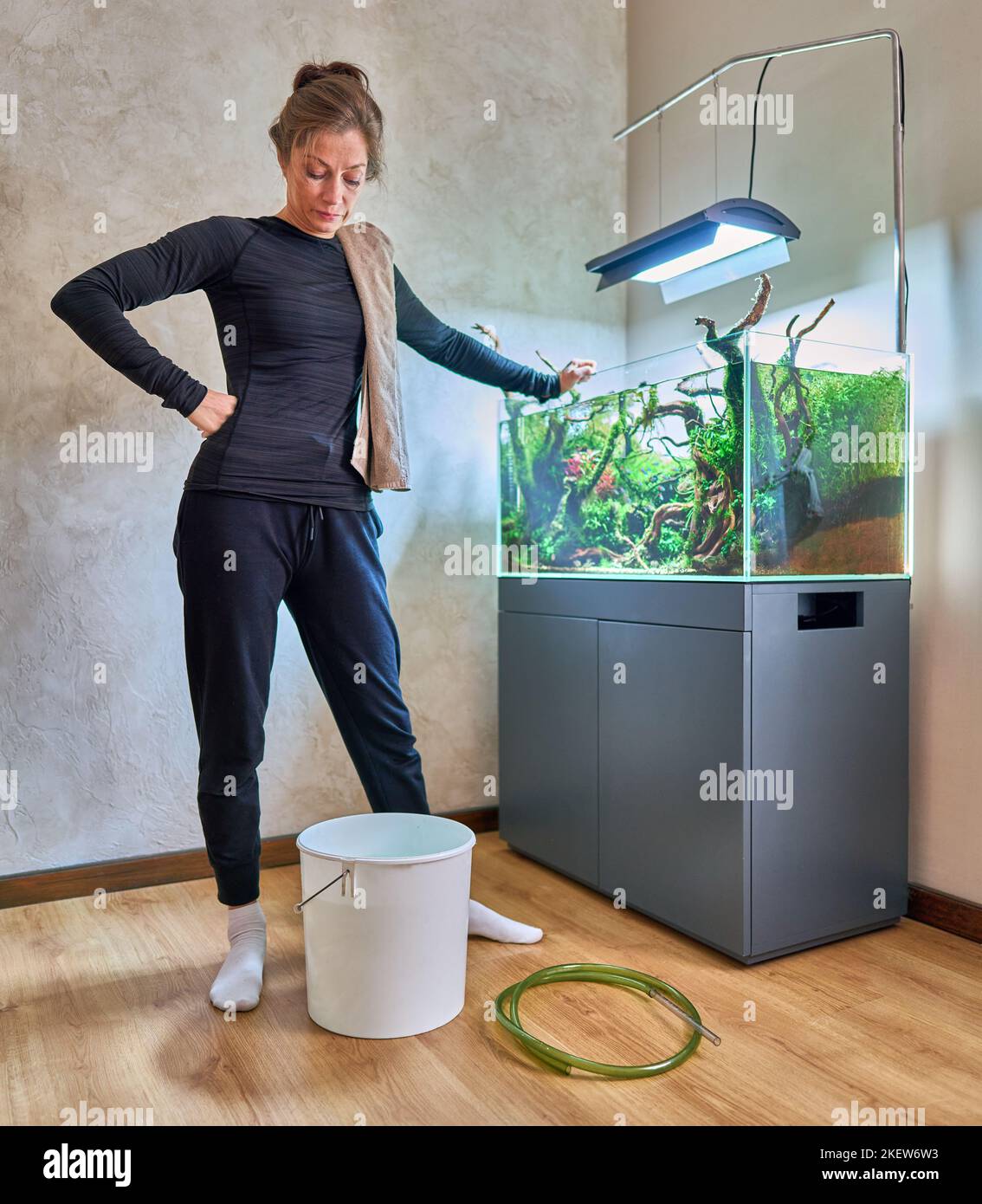 Une femme se tient près du seau blanc devant le paysage aquatique de l