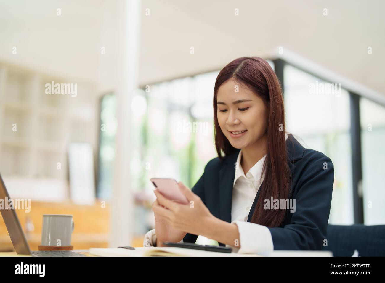 Femme d'affaires asiatique utilisant le téléphone pour contacter un partenaire d'affaires Banque D'Images