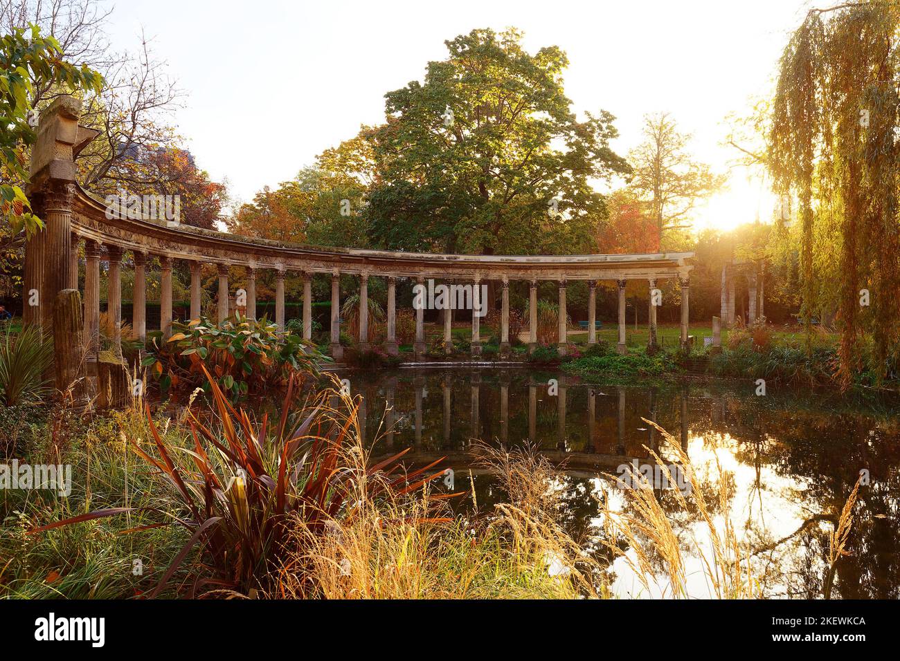 Les anciennes colonnes du Parc Monceau se reflètent dans l'eau du bassin ovale, au soleil . Ce jardin public est situé dans le 8th arrondissement Banque D'Images