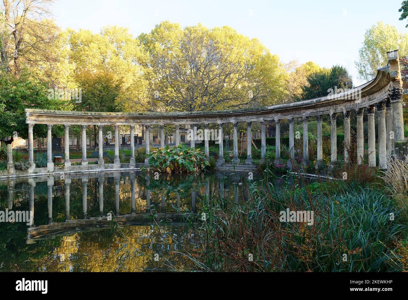 Les anciennes colonnes du Parc Monceau se reflètent dans l'eau du bassin ovale, au soleil . Ce jardin public est situé dans le 8th arrondissement Banque D'Images