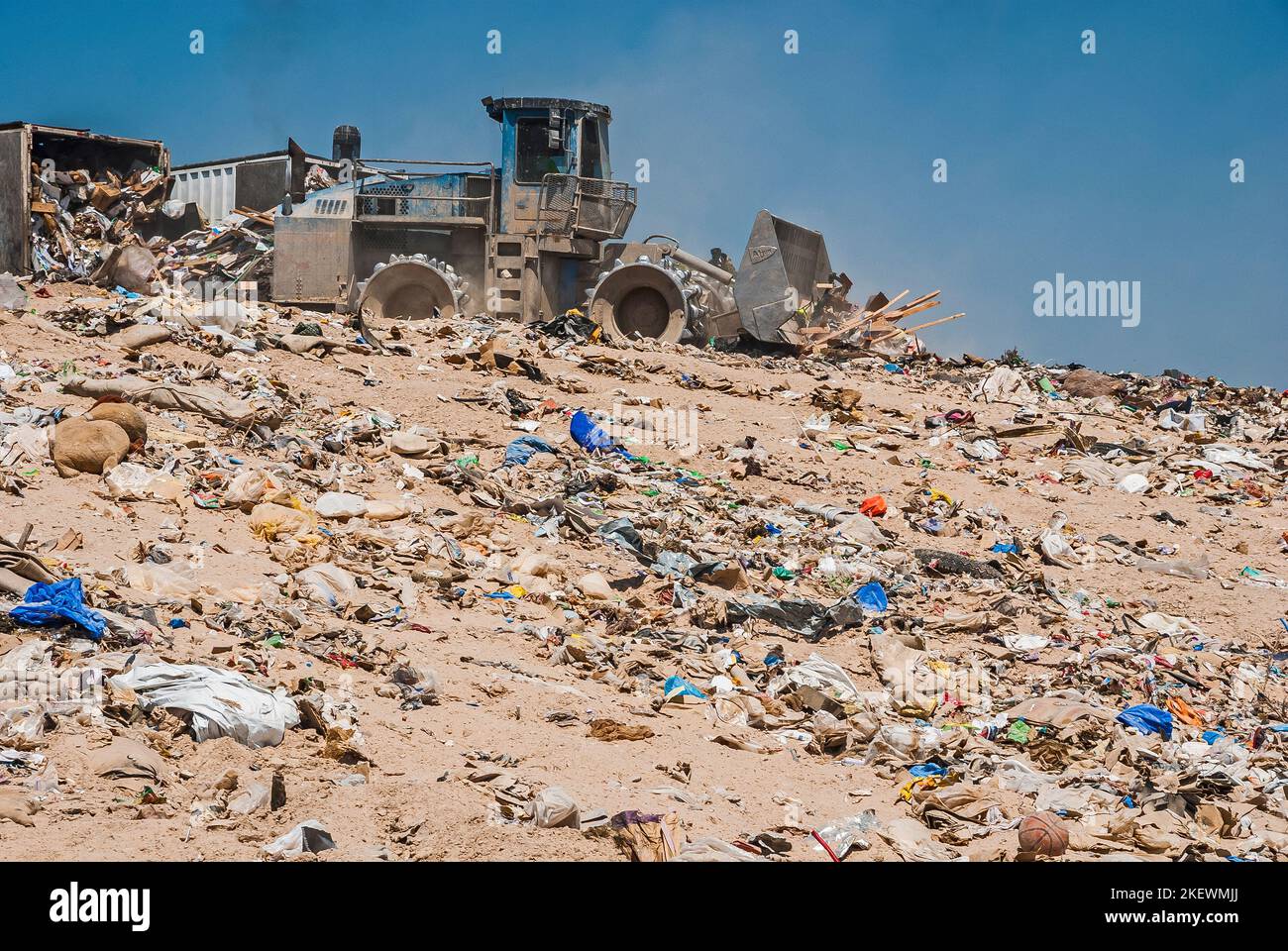 Un compacteur de sol et deux remorques déchargeant des déchets dans une ...