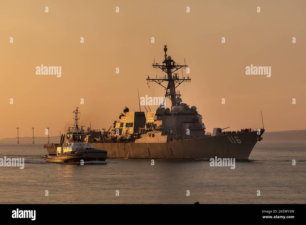 USS Thomas Hudner 116 un destroyer de la marine américaine arrivant à Portsmouth en début de matinée. Illuminé par le soleil du matin avec le ciel orange derrière. Banque D'Images