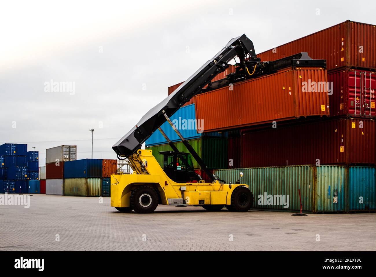 Chariot élévateur pour conteneur de chargement. Chargement du conteneur de fret. Gestionnaire de conteneur. Concept logistique d'importation et d'exportation. Chantier logistique de conteneurs industriels. Banque D'Images