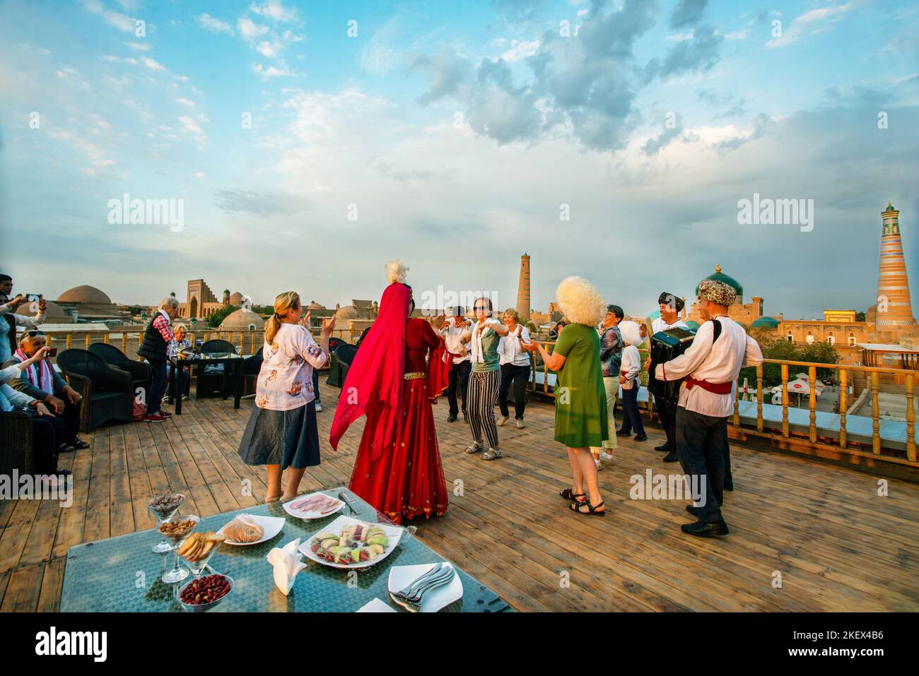 25-04-2022 Khiva, Ouzbékistan. Les touristes français dansent à la musique live d'un groupe folklorique ouzbek sur le toit du restaurant dans la vieille ville de Khiva. Le Banque D'Images