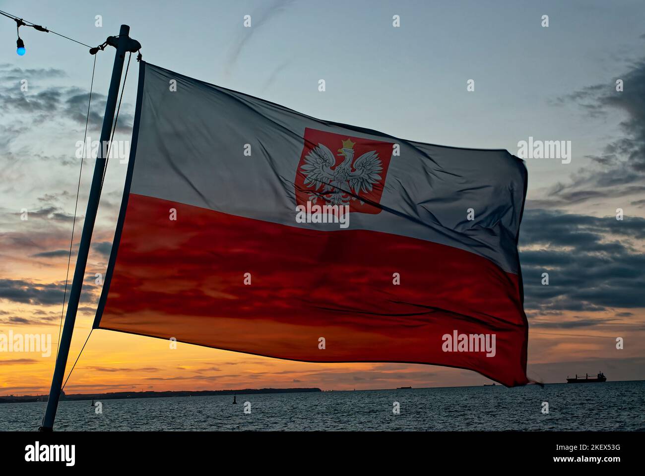 Drapeau maritime polonais, drapeau maritime de la Pologne, drapeau polonais dans le vent, ciel du soir. Le drapeau actuellement valide dans la navigation civile. Banque D'Images