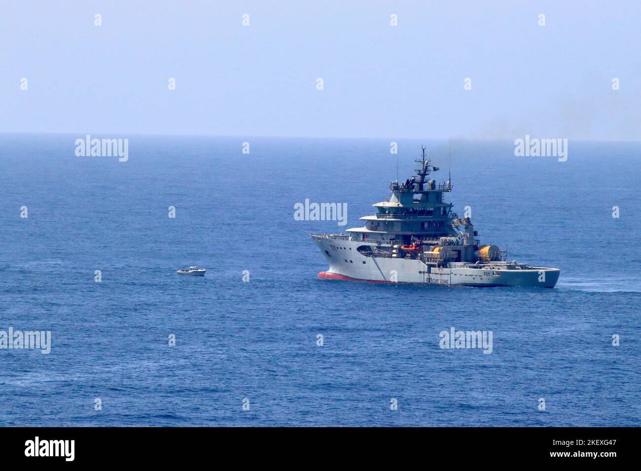 Navire de sauvetage naval algérien 701 l'Al-Munjid (El Mounjid) tourne autour d'un bateau migrant abandonné qui dérive sans électricité en mer Méditerranée. Banque D'Images