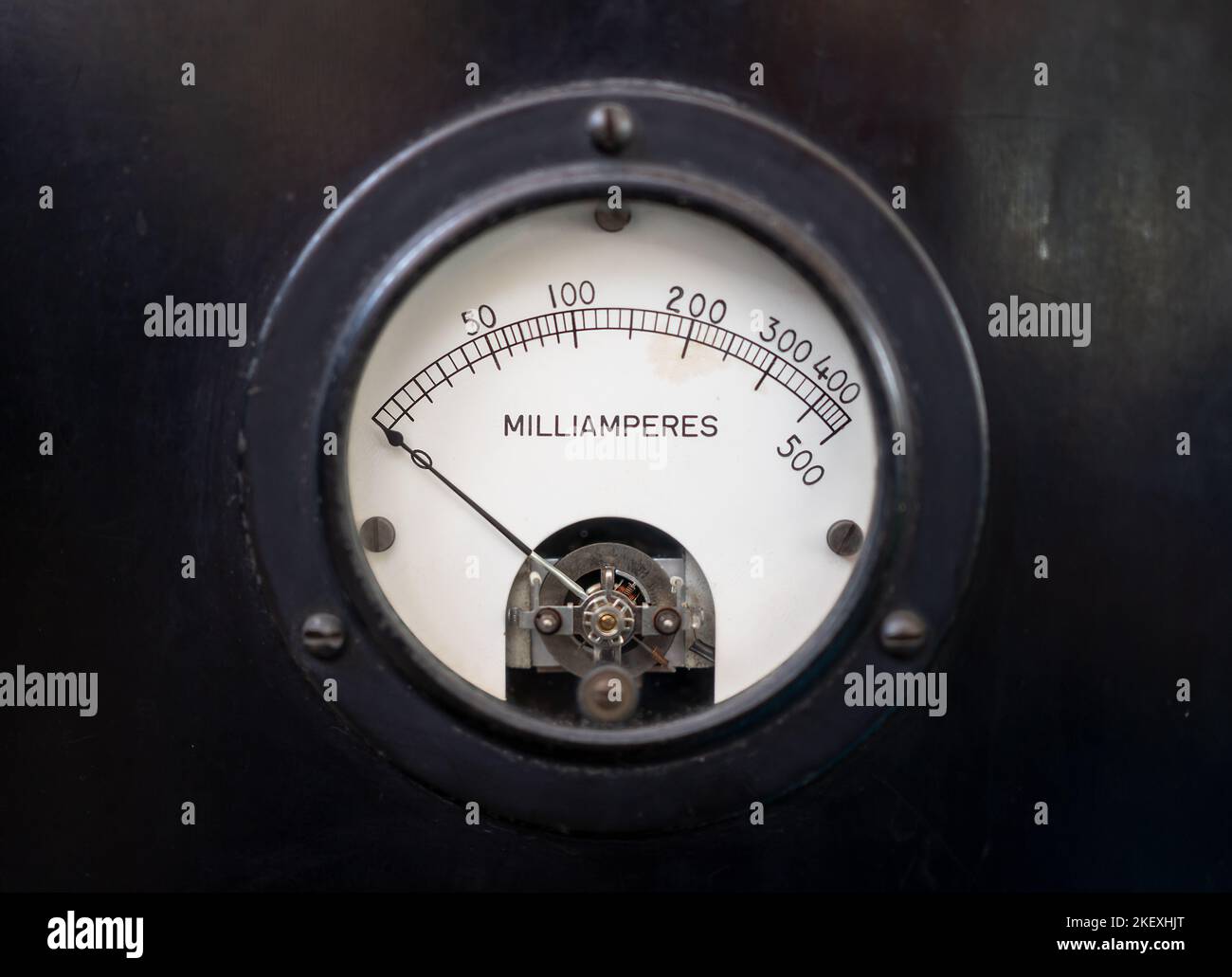 Gros plan d'un ancien milliamètre analogique pour 500 milliampère de courant continu, isolé en noir. Banque D'Images