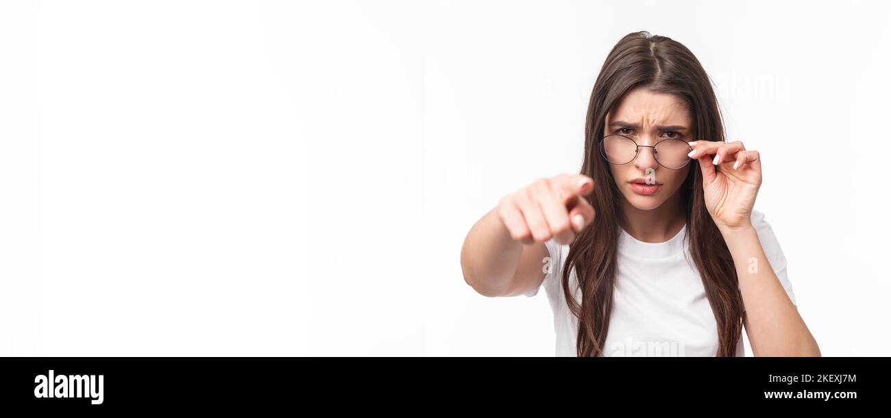 Gros plan portrait d'une femme suspecte, judgmentale dans des lunettes, blâmer quelqu'un, frognant, se calant sur la personne qu'elle blâme, pointant des accusations de doigt Banque D'Images