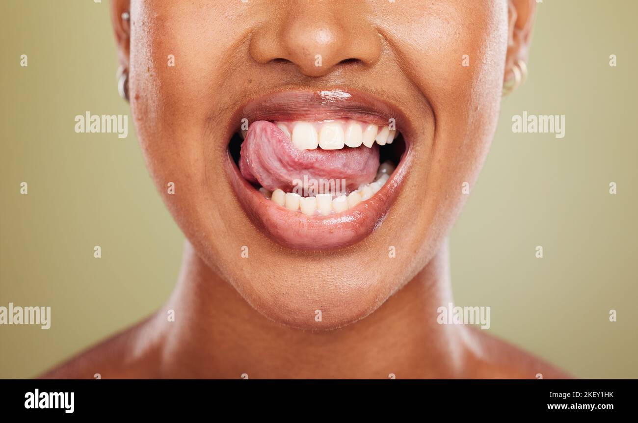 Langue, dents et femme africaine en gros plan avec lécher, sourire ou heureux pour le bien-être dentaire en studio. Modèle, bouche ou dents de blanchiment parfait pour la santé Banque D'Images