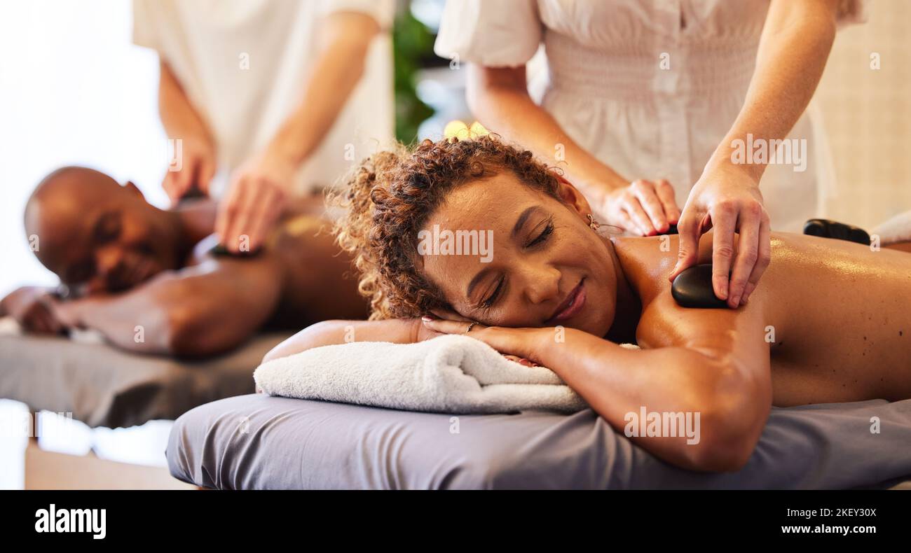 Spa, bien-être et massage pour couple et thérapie de pierres chaudes, massage des mains de thérapeute pour le soulagement du stress et la santé du corps. L'homme et la femme se détendent dans le luxe Banque D'Images