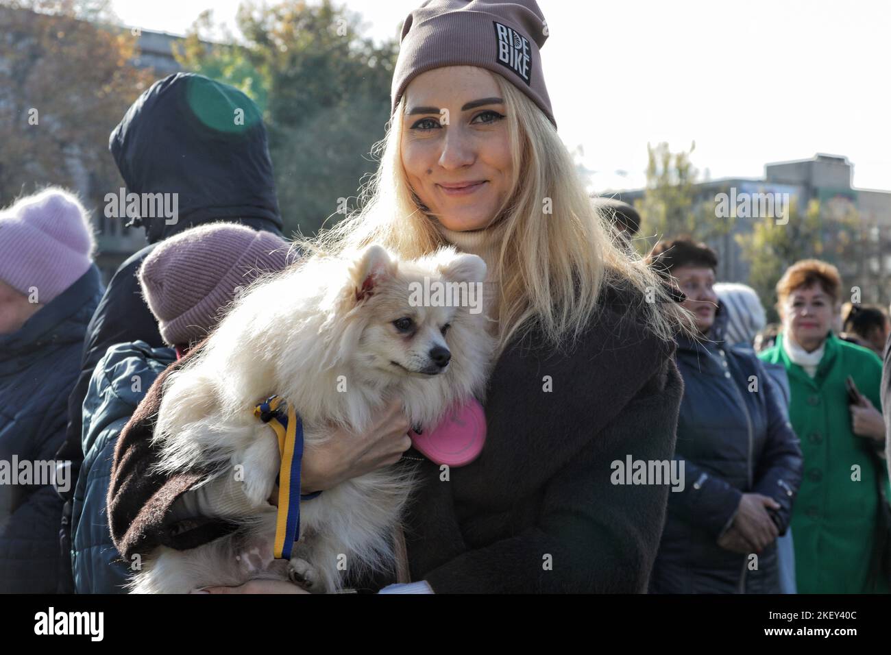 Non exclusif: KHERSON, UKRAINE - 14 NOVEMBRE 2022 - Une femme tient un chien avec un ruban aux couleurs nationales ukrainiennes dans le quartier central de Kherson Banque D'Images
