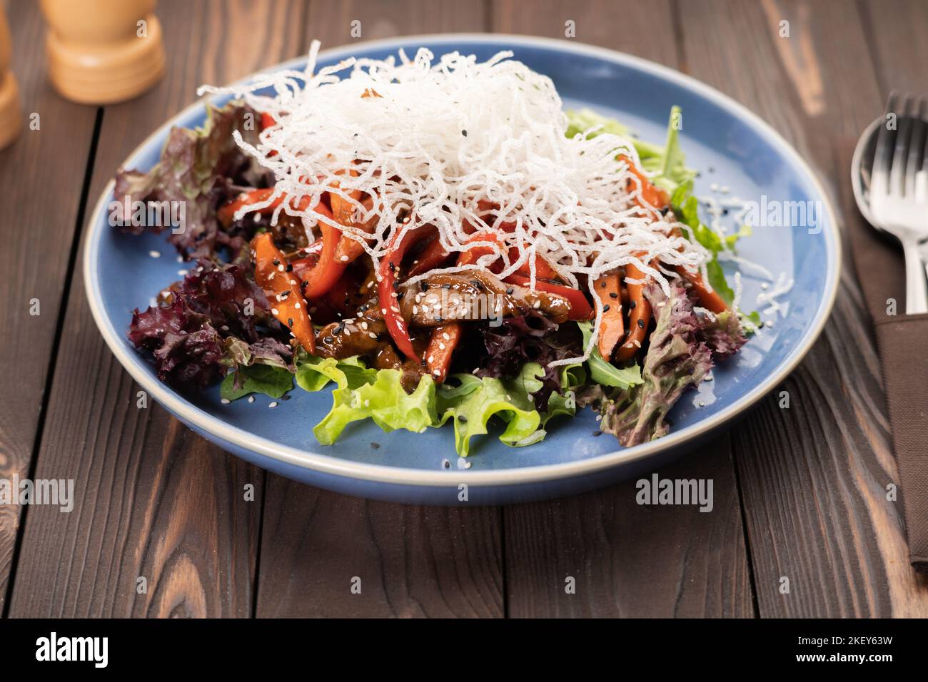 Délicieuse salade de bœuf thaï présentée dans une assiette bleue Banque D'Images