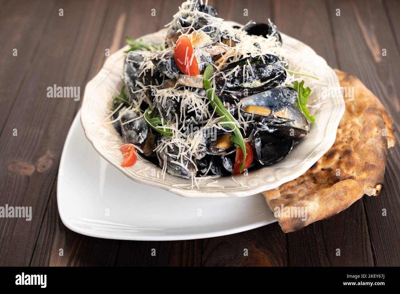 Moules fraîches à la tomate, pain géorgien, fromage dans un petit bol blanc Banque D'Images