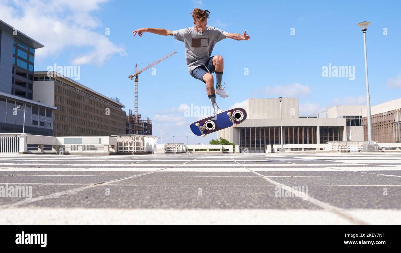 Le patinage est plus qu'un passe-temps. Un jeune homme skate à travers la ville. Banque D'Images