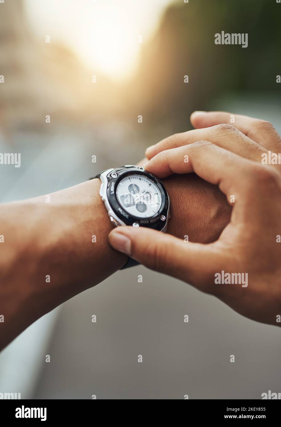 Il est temps de couvrir quelques kilomètres. Un coureur qui vérifie sa montre de sport pendant son entraînement. Banque D'Images