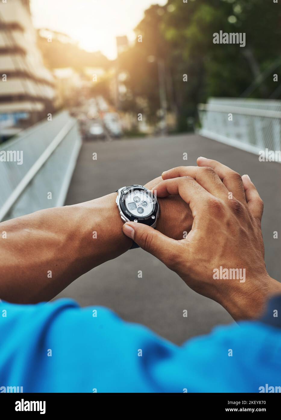 En essayant de battre son record personnel, un coureur qui vérifie sa montre de sport pendant son entraînement. Banque D'Images
