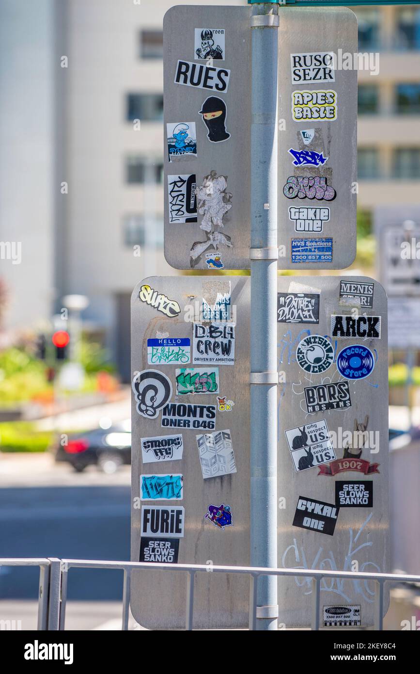 La guérilla marketing sous forme d'autocollants ou de décalcomanies collés dans les lieux publics comme l'arrière de ces panneaux de rue à Sydney, en Australie Banque D'Images