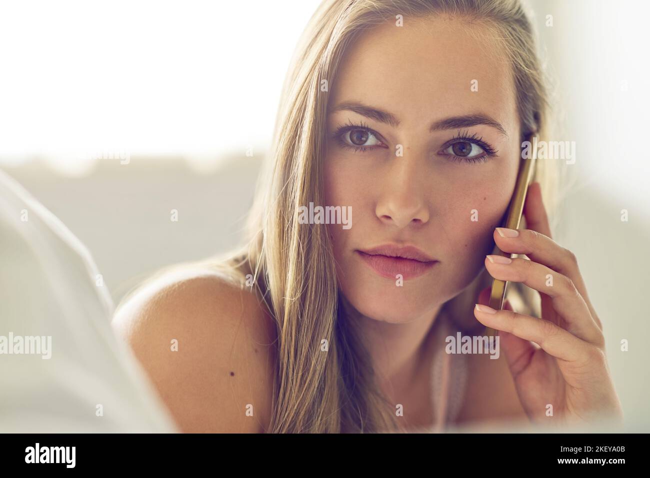 Faire cet appel. Une jeune femme parlant sur son téléphone à la maison. Banque D'Images