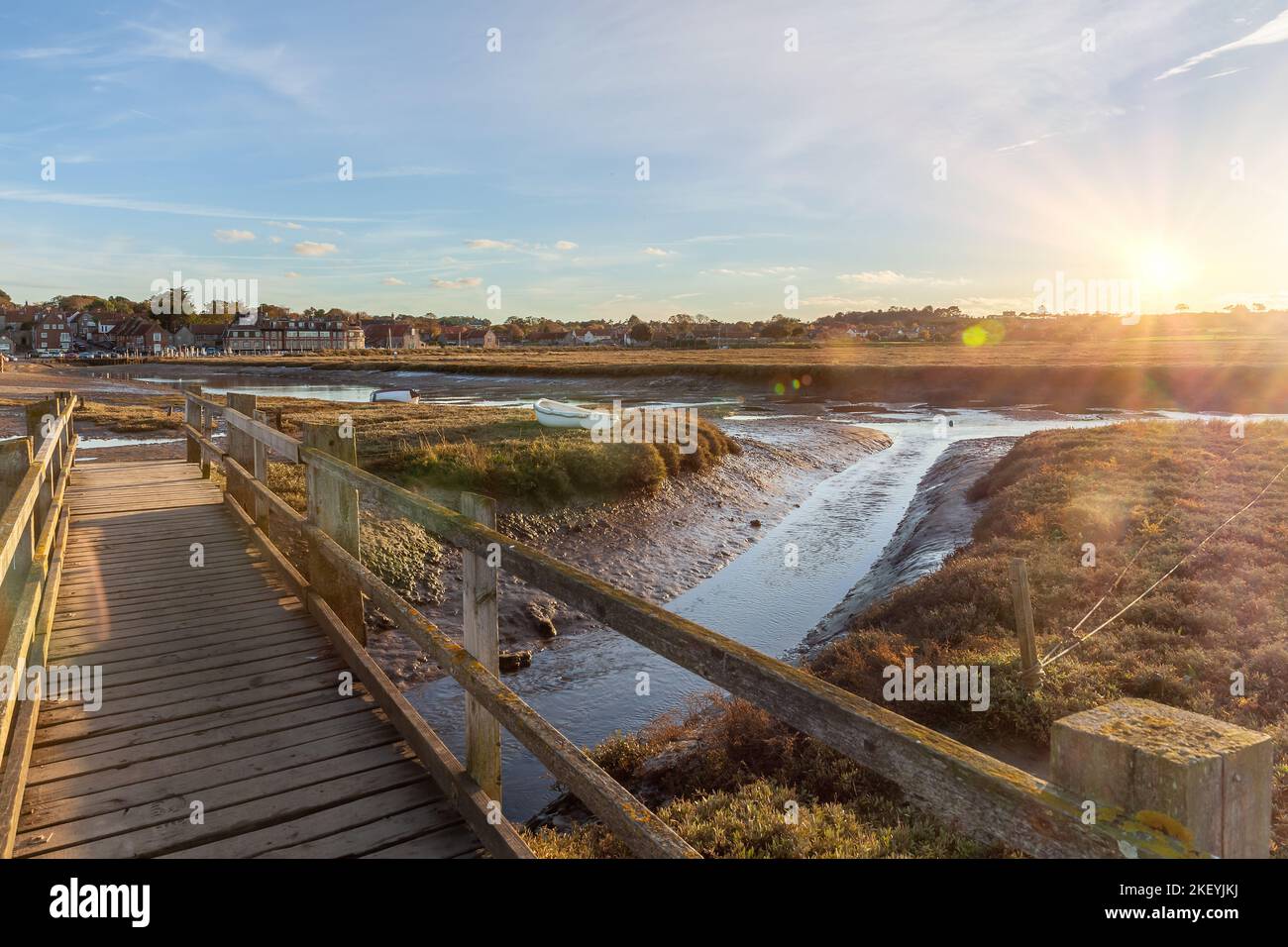 Pont en bois à pied du quai Blakeney à Norfolk, Royaume-Uni, au coucher du soleil. Ruisseau à marée basse et sortie d'eau vers la mer Banque D'Images