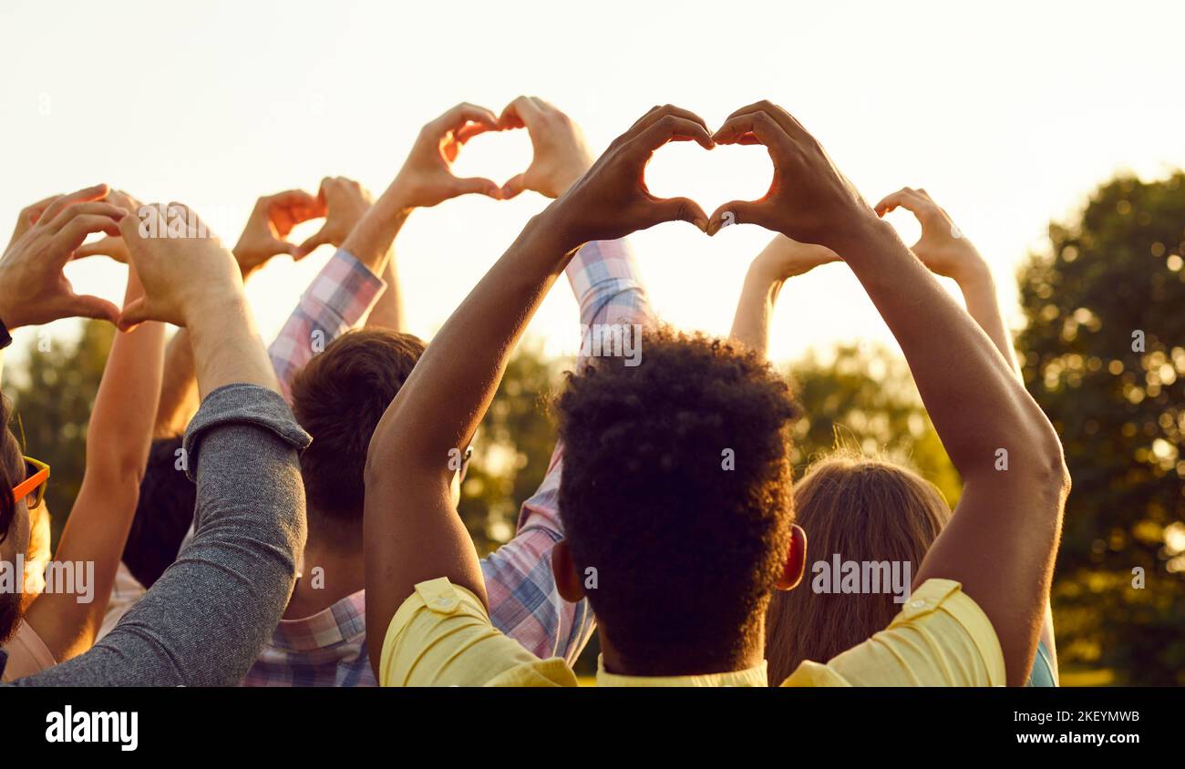 Groupe de personnes multiraciales heureuses espérant la paix et faisant des gestes en forme de cœur Banque D'Images