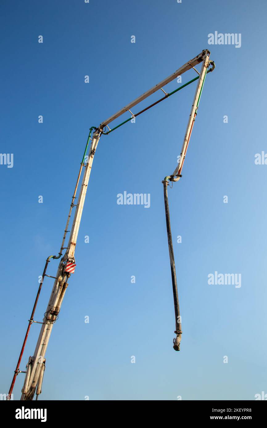 La flèche du camion-pompe à béton est prête pour le transport du béton sur le chantier de construction. Banque D'Images