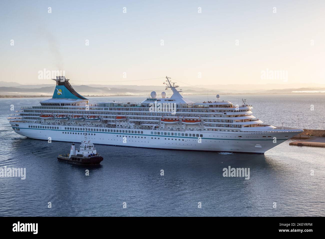 Artania bateau de croisière arrivant à une ville touristique Port pendant le lever du soleil. Banque D'Images