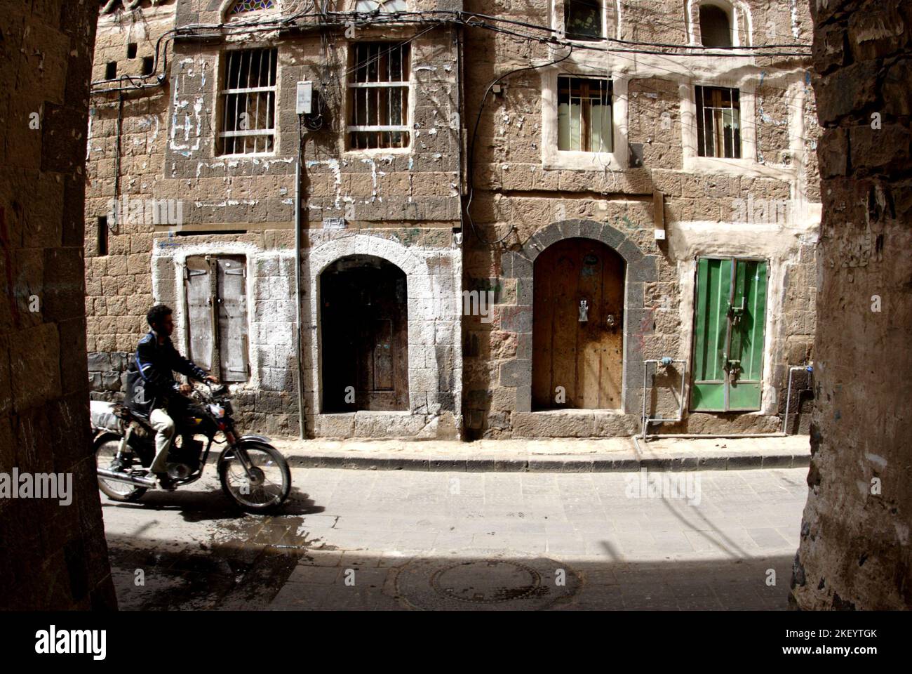 Un motocycliste dans la ruelle de la vieille ville, Sana’a, Yémen Banque D'Images