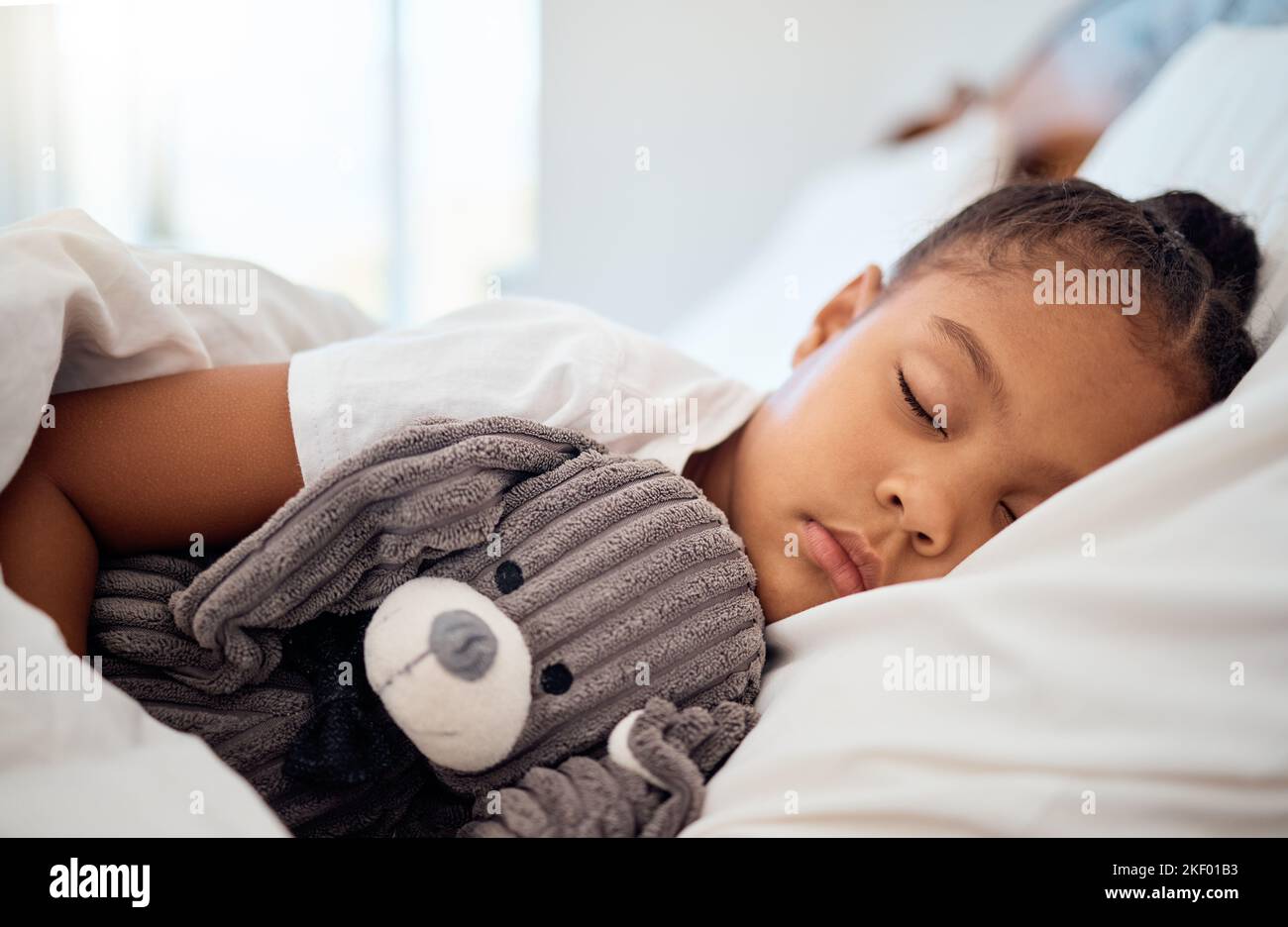 Paix, matin et bien-être d'enfant noir dormant dans un lit confortable avec peluche à la maison le week-end. Détendez-vous, dormez et la santé d'un enfant qui rêve Banque D'Images