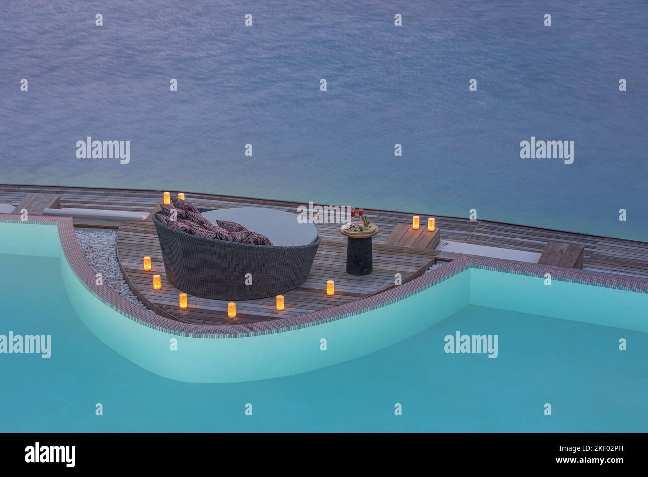 Bougies au bord de la piscine le soir. Dîner privé romantique avec chaise longue et vue sur la mer. Luxe lune de miel d'été, couple romantique destination Banque D'Images