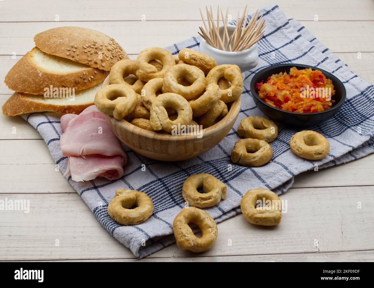 Taralli alla pugliese avec de l'huile d'olive extra vierge dans un bol en bois. En-cas italien traditionnel, taralli Banque D'Images