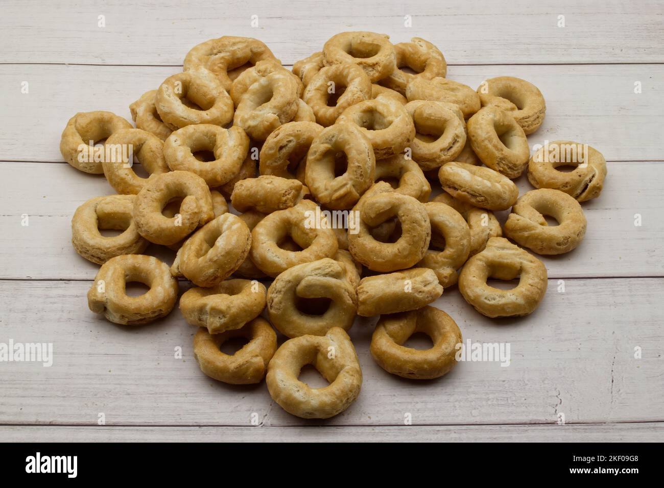 Taralli alla pugliese avec de l'huile d'olive extra vierge sur fond de bois. En-cas italien traditionnel, taralli Banque D'Images