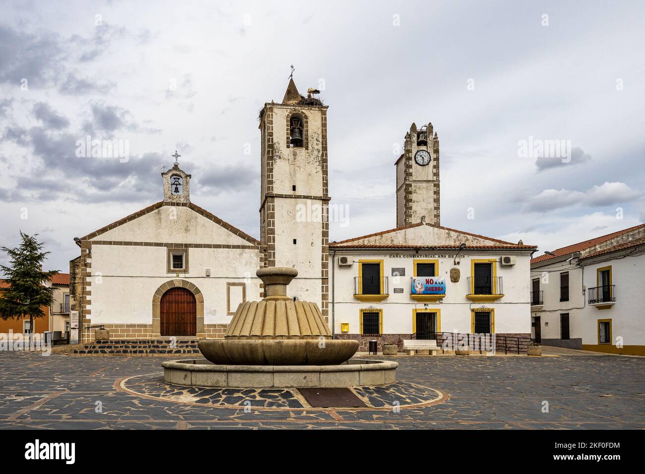 Nid de cigognes au sommet de l'ancien clocher en pierre avec croix de fer à Herreruela, Estrémadure en Espagne. Le paradis des randonneurs. Banque D'Images