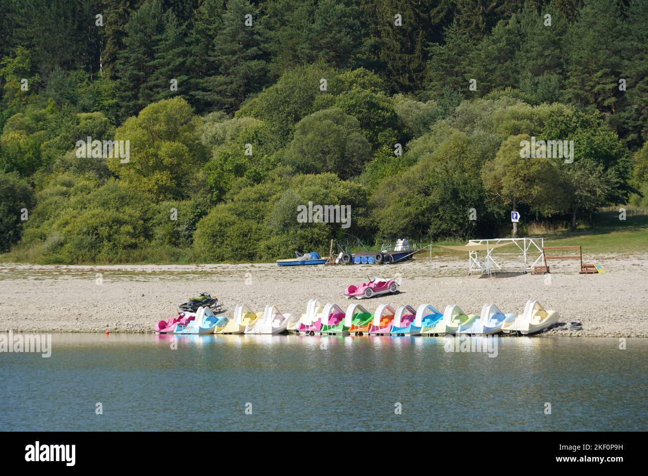 Vue directe sur le lac avec centre de sports nautiques qui loue des bateaux, des motomarines, des planches SUP et des vélos. Banque D'Images