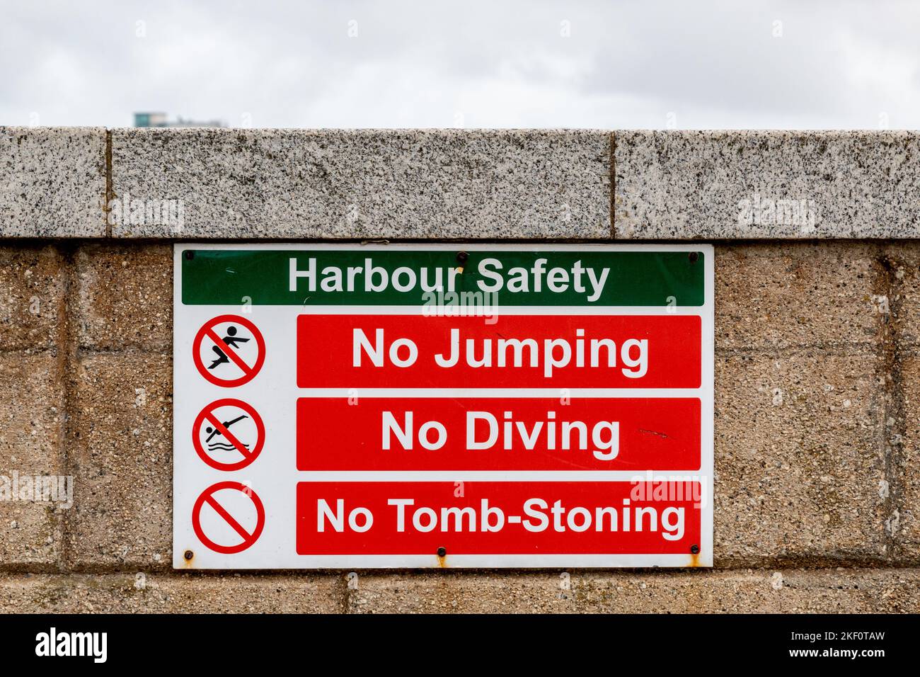 Le panneau de sécurité du port situé sur le mur du port de Newquay interdit le saut, la plongée et le lapidation des tombes. Banque D'Images
