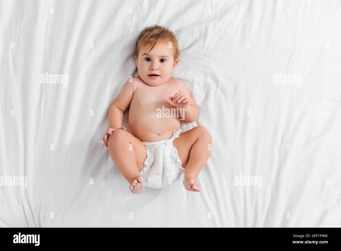 Beau sourire mignon bébé. Portrait en gros plan de bébé couché heureux regardant l'appareil photo Banque D'Images