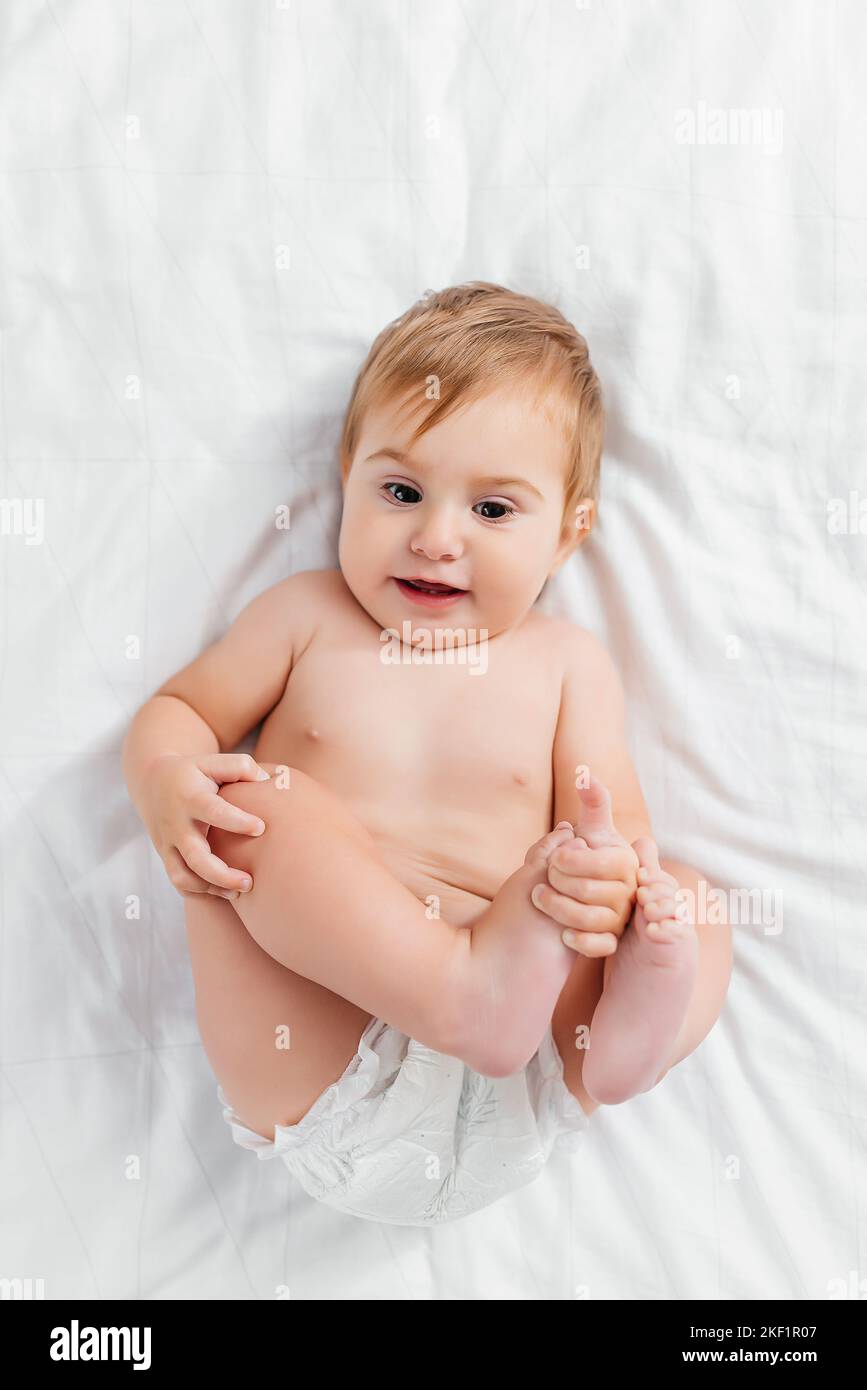 Beau sourire mignon bébé. Portrait en gros plan de bébé couché heureux regardant l'appareil photo Banque D'Images