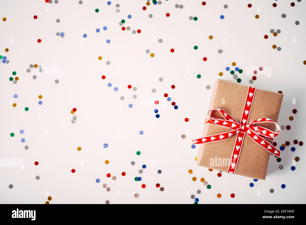 Boîte cadeau ou cadeau et confettis sur la table blanche sur le dessus. Arrangement plat pour l'anniversaire, la fête des mères ou le jour de valentinas Banque D'Images