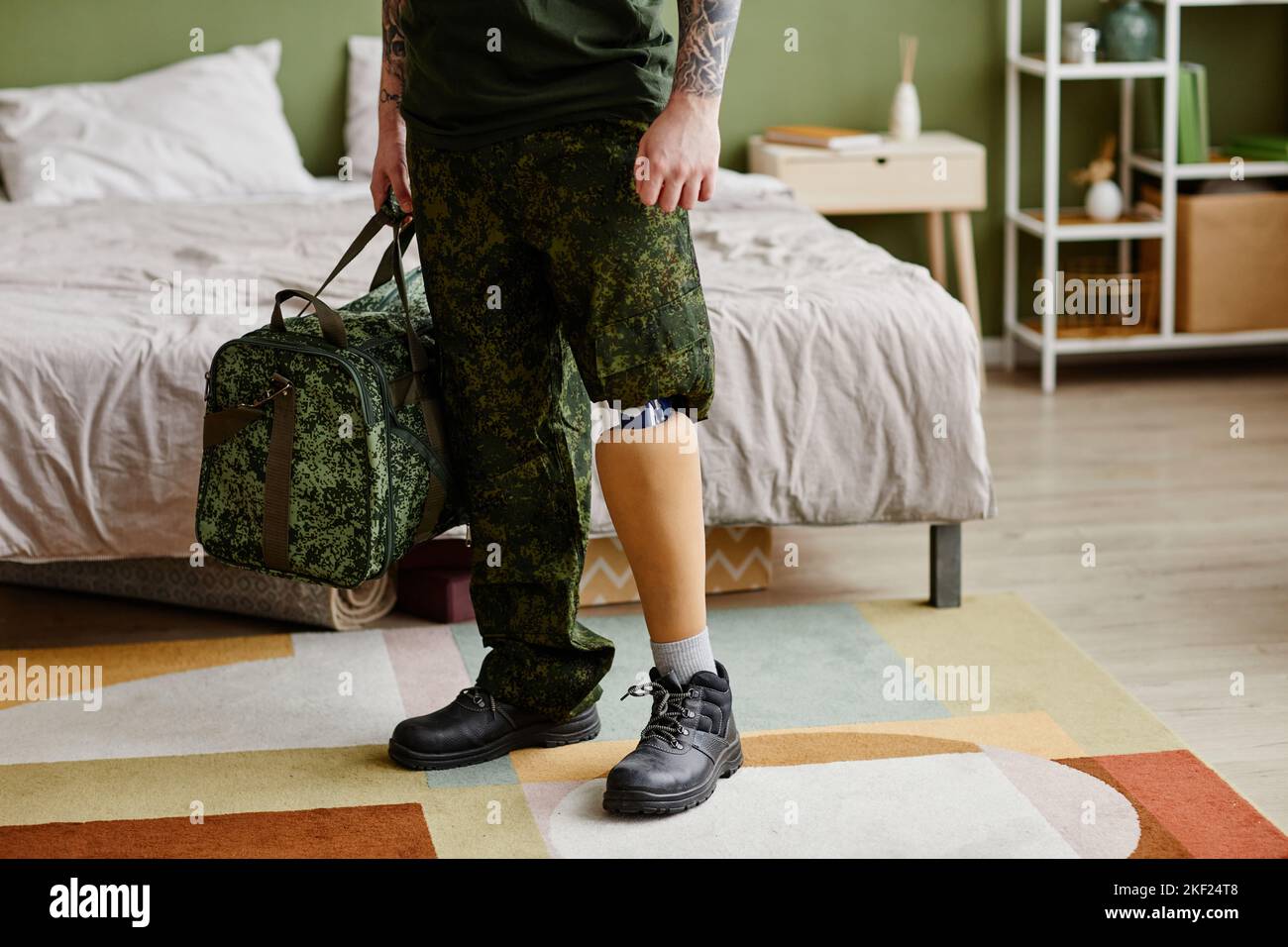 Gros plan d'un vétéran militaire avec une jambe prothétique portant un uniforme militaire à la maison, espace de copie Banque D'Images